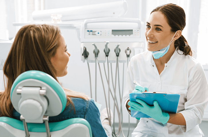 A dentist and her patient discuss treatment.