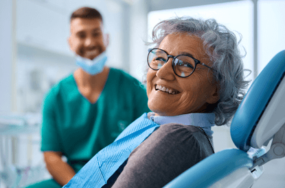 A smiling woman sits in the dentist’s office.