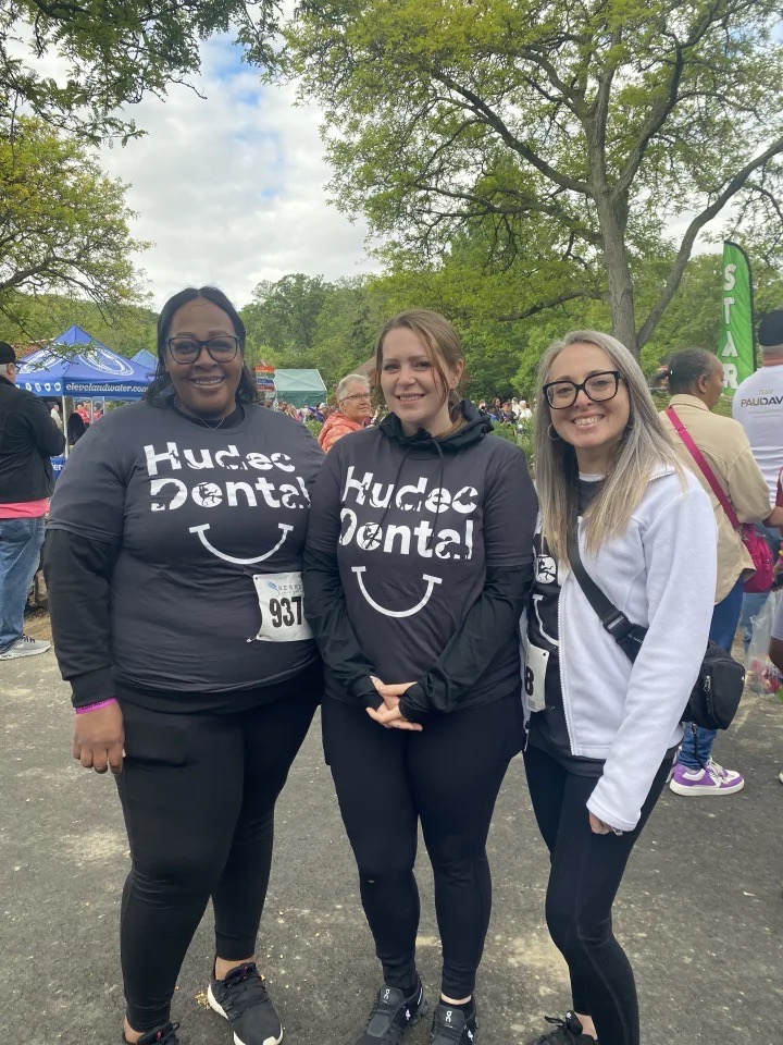Hudec Dental employees smiling wearing matching shirts at the zoo walk