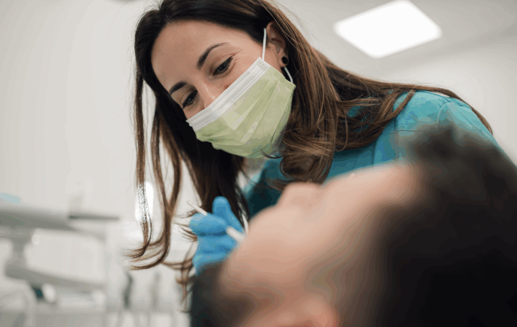 Female dental worker applying fluoride treatment on a client.